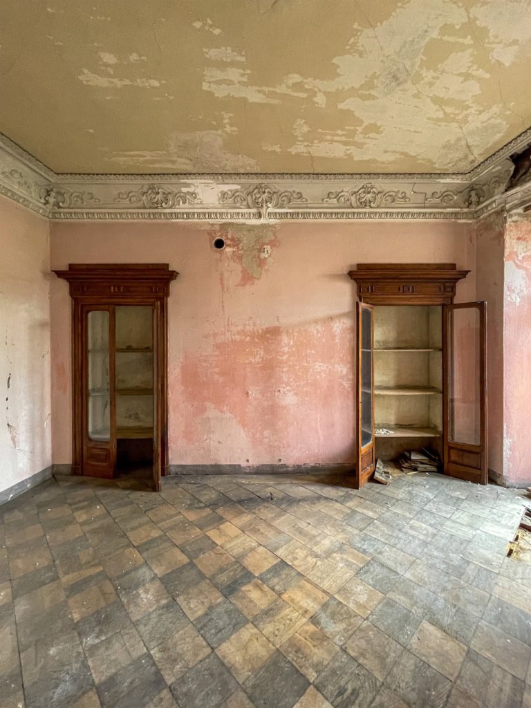 Mendrisio. Deux armoires murales surplombent un ancien parquet, mur rose défraîchi.